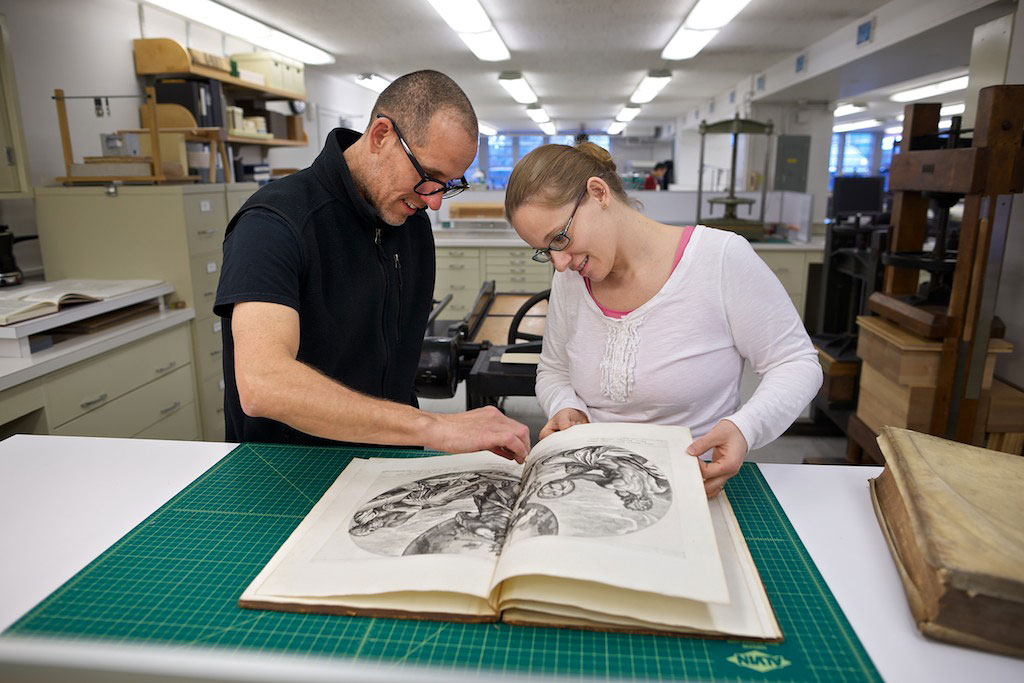 Mick LeTourneaux, Rare Books Conservator, and Jessica Dagci, Marquand Special Assistant, plan the restoration of a rare Marquand Text. Firestone Library, Princeton University. December, 2013.