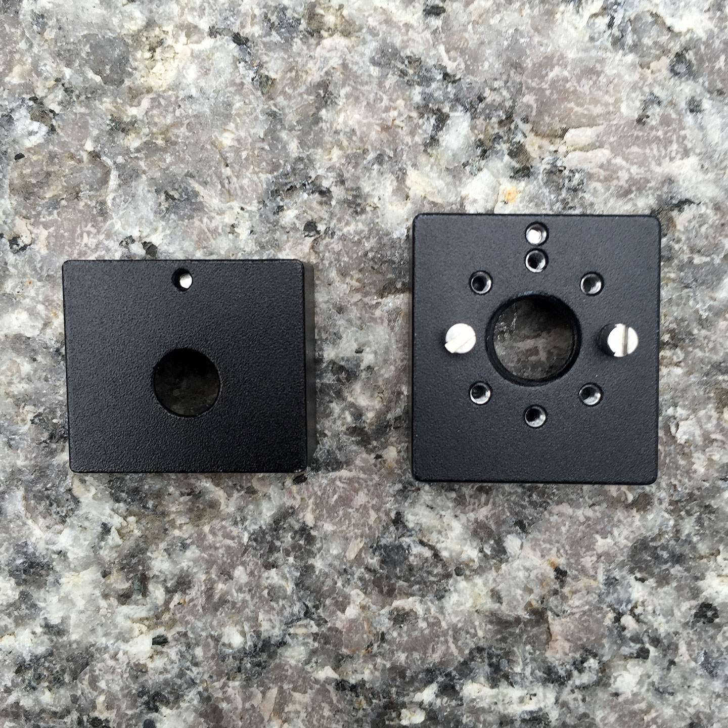 The bottom of Wooden Camera's ¼-20 Hot Shoe (left) vs. its Universal Hot Shoe. The latter is positionable and removable guide pins.
